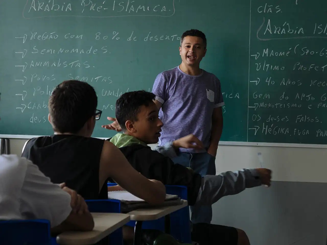 Homem ensina uma classe de alunos