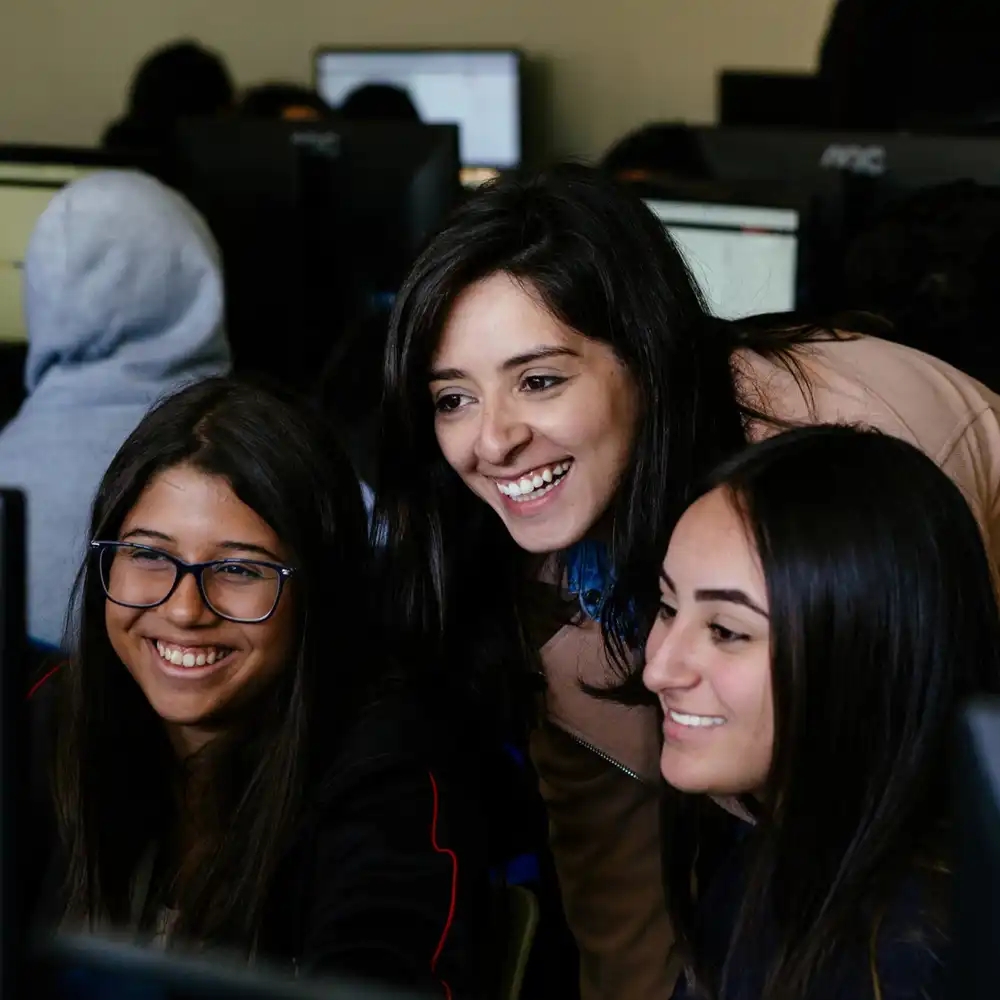 Trois étudiants utilisent l'apprentissage gratuit IBM SkillsBuild en classe