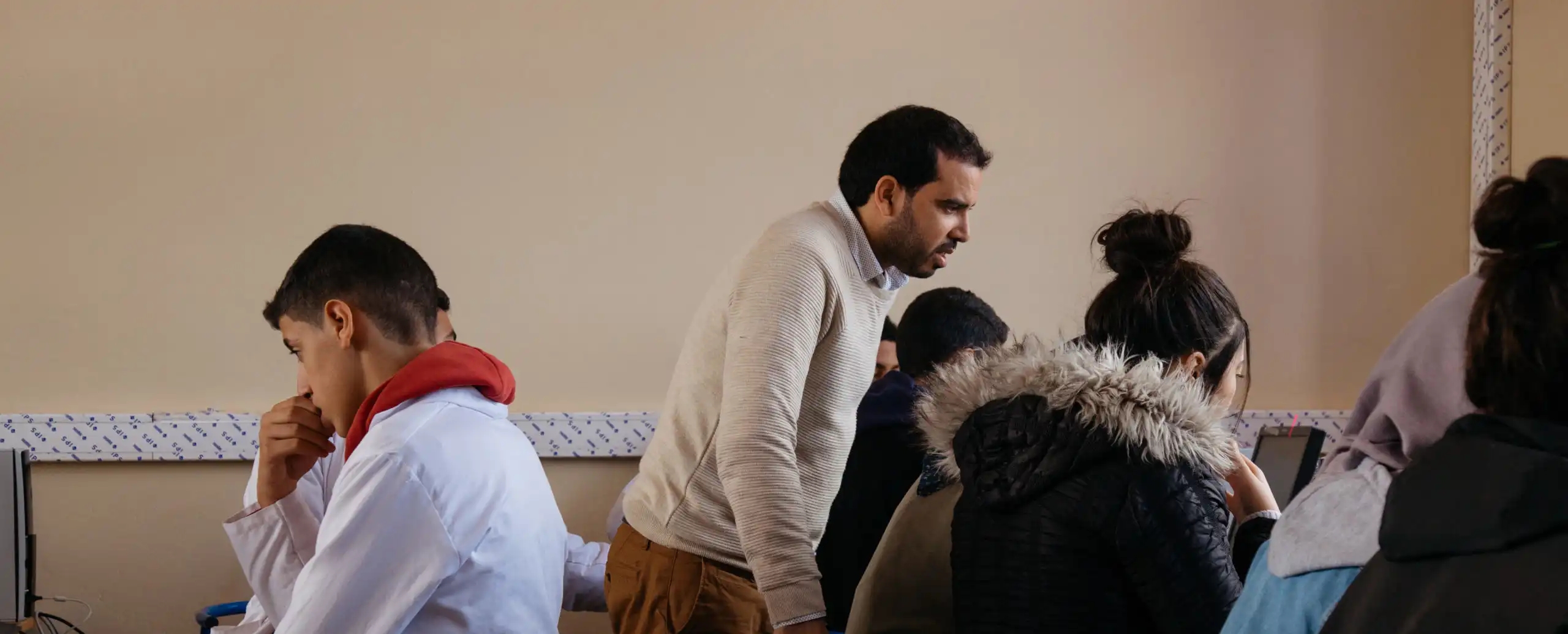 Teacher looking over the work of students