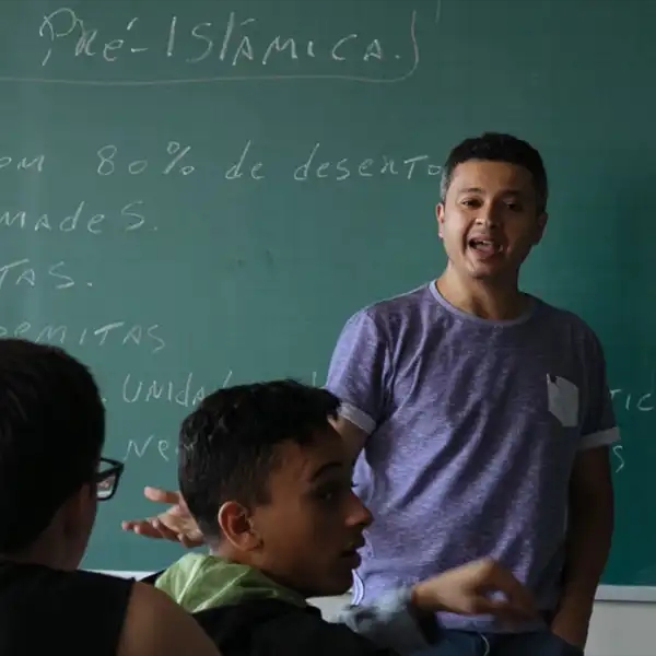 O professor em frente ao quadro-negro explicando um tópico para a sala de aula