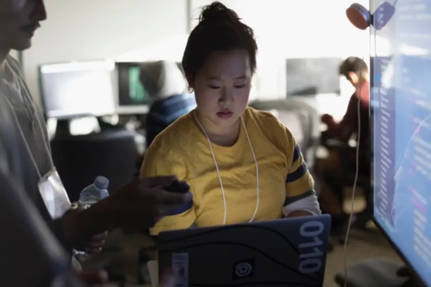 Woman working with co-worker in front of laptop