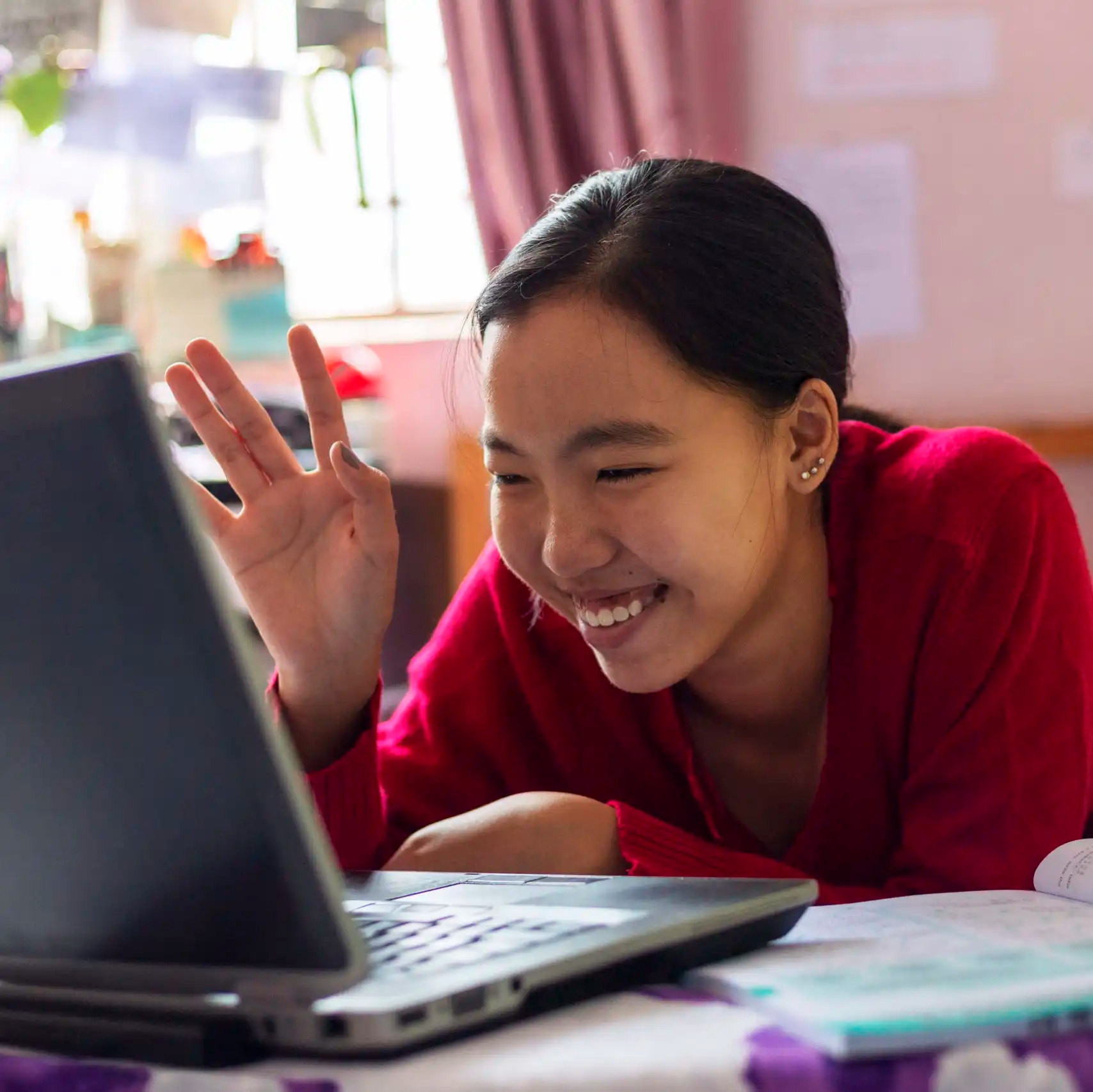 Young girl uses her laptop for virtual class from her home