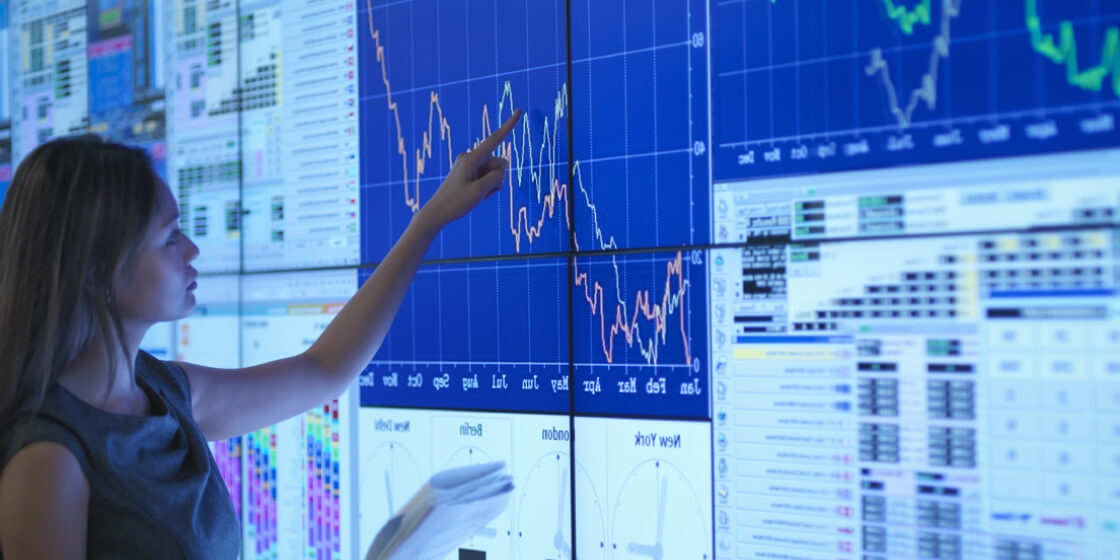 Woman studying analysis charts in front of a touch digital screen